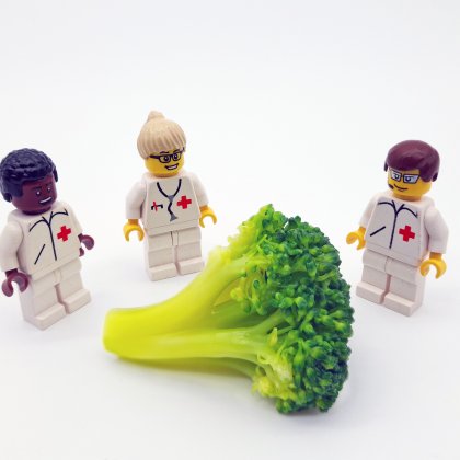 LEGO doctors beside a huge broccoli.